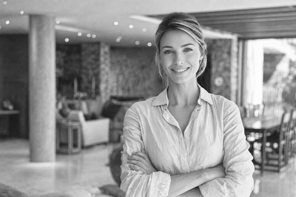 Client-Centric Architects: Creating Exceptional Client Experiences 1 Smiling woman standing with folded arms in a bright residential interior.